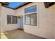 View of stucco exterior with light-blue door flanked by windows providing natural light to the home at 445 Intrepid Ct, Boulder City, NV 89005