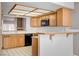 Cozy kitchen showcasing oak cabinets, black appliances, and a functional breakfast bar with decorative corbels at 445 Intrepid Ct, Boulder City, NV 89005