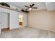 Large carpeted main bedroom with a ceiling fan, and an en-suite bathroom beyond the doorway at 445 Intrepid Ct, Boulder City, NV 89005