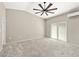 Large bedroom featuring neutral paint and carpet, ceiling fan, and glass sliding door at 4620 E Suntree Ct, Pahrump, NV 89061