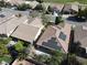 Aerial view of tile-roofed homes, lush foliage, and solar panels atop one residence in a desirable neighborhood at 5439 E Cansano St, Pahrump, NV 89061