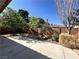 Well-maintained backyard featuring a paved patio, rock landscaping, mature trees, and an attractive brick perimeter fence at 5439 E Cansano St, Pahrump, NV 89061
