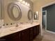 Bathroom featuring double sink vanity with dark cabinets, and decorative framed mirrors at 5439 E Cansano St, Pahrump, NV 89061