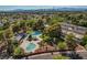 Aerial view of community pools, mature trees, and city skyline at 565 Greenbriar Townhouse Way, Las Vegas, NV 89121