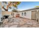Private backyard featuring flagstone patio, brick fireplace, and desert landscaping at 565 Greenbriar Townhouse Way, Las Vegas, NV 89121
