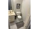 Small bathroom with a white toilet and vanity with a marble tile floor at 565 Greenbriar Townhouse Way, Las Vegas, NV 89121