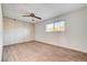 Bright bedroom featuring wood-look floors, a ceiling fan, and ample closet space at 565 Greenbriar Townhouse Way, Las Vegas, NV 89121