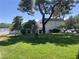 Well-manicured lawn and mature trees surrounding the home's exterior, offering a serene environment at 565 Greenbriar Townhouse Way, Las Vegas, NV 89121