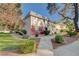 View of the townhome showcasing its tidy lawn, mature trees, and attractive landscaping at 565 Greenbriar Townhouse Way, Las Vegas, NV 89121