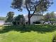 Lush green lawn with mature trees provides a serene and inviting landscape at 565 Greenbriar Townhouse Way, Las Vegas, NV 89121