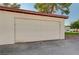 A single car garage with a white door and exterior paint at 565 Greenbriar Townhouse Way, Las Vegas, NV 89121