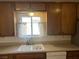 Traditional kitchen featuring a sink with a window and wooden cabinets at 565 Greenbriar Townhouse Way, Las Vegas, NV 89121