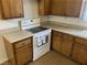 Bright kitchen featuring wooden cabinets and a white electric range at 565 Greenbriar Townhouse Way, Las Vegas, NV 89121