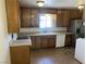 Traditional kitchen with wooden cabinets, tile floors, and a stainless-steel refrigerator at 565 Greenbriar Townhouse Way, Las Vegas, NV 89121