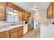 Charming kitchen featuring stainless steel appliances, tile floors, and view of 2nd story stairs at 565 Greenbriar Townhouse Way, Las Vegas, NV 89121