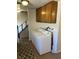 Laundry area with a stacked washer and dryer, and wooden cabinets at 565 Greenbriar Townhouse Way, Las Vegas, NV 89121