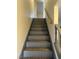 View up a gray staircase with a wooden handrail and patterned stair runners at 565 Greenbriar Townhouse Way, Las Vegas, NV 89121