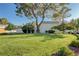 Well-maintained front yard with mature trees and landscaping at 565 Greenbriar Townhouse Way, Las Vegas, NV 89121