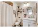Cozy bathroom featuring decorative shelves, a round mirror, and a shower with a charming patterned curtain at 5908 Marbrisas Ln, Las Vegas, NV 89130