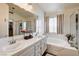 Well-lit bathroom featuring dual sinks, a soaking tub, and a glass-enclosed shower, blending style and functionality at 5908 Marbrisas Ln, Las Vegas, NV 89130
