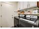 Well-equipped laundry room showcasing modern, front-loading washer and dryer, complemented by upper cabinetry at 5908 Marbrisas Ln, Las Vegas, NV 89130