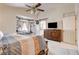 Bright main bedroom with a large bed and dresser with a TV, and a view to the en-suite bathroom at 5908 Marbrisas Ln, Las Vegas, NV 89130