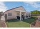 Spacious backyard offers a covered patio and well-manicured landscaping with artificial grass at 6138 Crystal Flower Way, North Las Vegas, NV 89031
