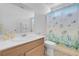 Neutral bathroom features a vanity with a sink, a toilet, and a shower with sea-themed curtain at 6138 Crystal Flower Way, North Las Vegas, NV 89031