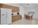 Bright kitchen with wooden cabinets, white appliances, tile floors, and a dining area at 6138 Crystal Flower Way, North Las Vegas, NV 89031