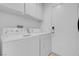 Efficient laundry room features a washer, dryer, storage cabinets, and a utility door at 6138 Crystal Flower Way, North Las Vegas, NV 89031