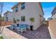 Charming backyard featuring a brick patio, stylish patio furniture, and decorative trees at 66 Chelsea Manor Ct, Las Vegas, NV 89110