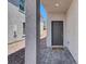Home entrance featuring a gray modern front door, concrete pillar and stone pavers at 66 Chelsea Manor Ct, Las Vegas, NV 89110