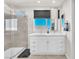 Bathroom featuring double sinks, a large mirror, white cabinets, and a tiled shower with glass doors at 690 Great Dane Ct, Henderson, NV 89052