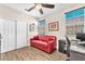 Cozy bedroom featuring a comfortable red couch, modern desk and double door closet at 690 Great Dane Ct, Henderson, NV 89052