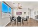 Bright dining room with hardwood floors, sleek table set, modern lighting fixture and a large window at 690 Great Dane Ct, Henderson, NV 89052