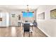 Bright dining room with hardwood floors, sleek table set, modern lighting fixture and large window at 690 Great Dane Ct, Henderson, NV 89052