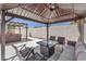 Covered gazebo with seating area and table, next to a pergola-covered hot tub for outdoor relaxation at 690 Great Dane Ct, Henderson, NV 89052