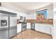 Modern kitchen with stainless steel appliances, granite countertops, and white cabinetry at 690 Great Dane Ct, Henderson, NV 89052