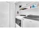 Laundry room with modern side-by-side washer and dryer and built-in shelves at 690 Great Dane Ct, Henderson, NV 89052