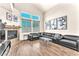 Bright living room with modern fireplace, plush couches, large windows and hardwood floors at 690 Great Dane Ct, Henderson, NV 89052