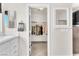 Hallway with view into a walk-in closet with rack and shelves plus hall bath with mirror and vanity at 690 Great Dane Ct, Henderson, NV 89052