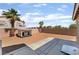 Spacious backyard featuring desert landscaping, a custom dog house, and a concrete patio at 7288 Quarterhorse Ln, Las Vegas, NV 89148