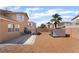 The backyard features desert landscaping, a custom dog house, a patio and built in grill at 7288 Quarterhorse Ln, Las Vegas, NV 89148