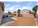 Expansive backyard boasts desert landscaping, a custom dog house, and a comfortable patio area at 7288 Quarterhorse Ln, Las Vegas, NV 89148
