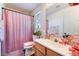 Brightly decorated bathroom with pink accents featuring a shower and sink with a large mirror at 7288 Quarterhorse Ln, Las Vegas, NV 89148