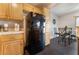 Cozy kitchen showcasing a black refrigerator, and black tile flooring leading to dining area at 7288 Quarterhorse Ln, Las Vegas, NV 89148