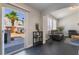 Bright living room with black tile floors, leading to an outdoor patio with a palm tree view at 7288 Quarterhorse Ln, Las Vegas, NV 89148