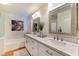 Bright bathroom with dual sinks, white cabinets, a soaking tub and decorative artwork at 7648 Rolling View Dr # 201, Las Vegas, NV 89149