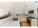 Modern kitchen with white cabinets, stainless appliances and countertops with a tile backsplash at 7648 Rolling View Dr # 201, Las Vegas, NV 89149