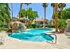 Community pool area featuring palm trees and a decorative rock waterfall at 7648 Rolling View Dr # 201, Las Vegas, NV 89149
